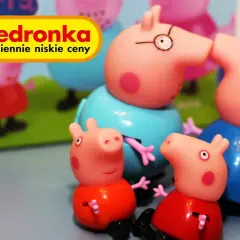 Urocza świnka Peppa zabawka z Biedronki. Rodzina świnek wesoło bawi się na tle zielonej trawy.